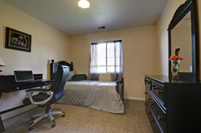 Big Rapids apartment for rent - a bedroom with a bed and a desk and a dresser