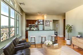 Baltimore apartment for rent - A living room with a bar area and a view of the city.