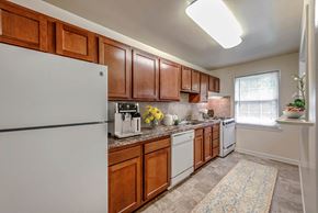 Glen Burnie apartment for rent - a kitchen with white appliances and wooden cabinets