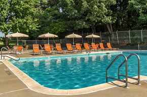 Woodbridge apartment for rent - a swimming pool with orange chairs and umbrellas