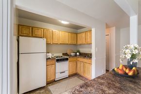 Bladensburg apartment for rent - a kitchen with white appliances and wooden cabinets