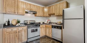 Hillcrest Heights apartment for rent - a kitchen with white appliances and wooden cabinets