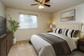 Lanham apartment for rent - a bedroom with a bed and a ceiling fan