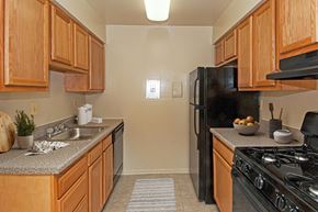 Lanham apartment for rent - a kitchen with black appliances and wooden cabinets