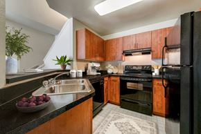 Adelphi apartment for rent - a kitchen with black appliances and wood cabinets