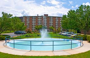 New Carrollton apartment for rent - a fountain in the middle of a pool in front of a building