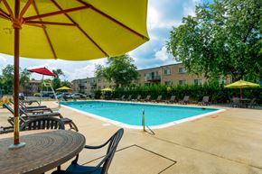 Hyattsville apartment for rent - a swimming pool with tables and chairs and umbrellas
