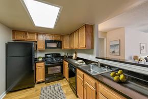 Baltimore apartment for rent - a kitchen with black appliances and wooden cabinets