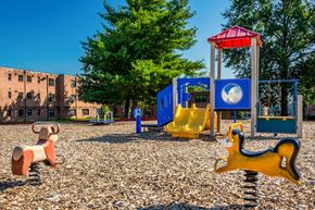 Hyattsville apartment for rent - a playground with a bunch of toys and a building in the background