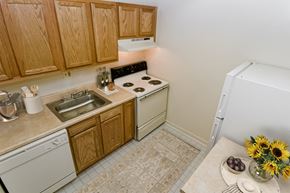 Silver Spring apartment for rent - a small kitchen with white appliances and wooden cabinets