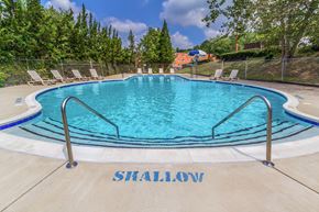 Hyattsville apartment for rent - a swimming pool with chairs and a fence around it