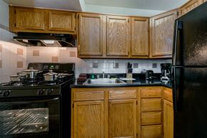 Laurel apartment for rent - a kitchen with black appliances and wooden cabinets
