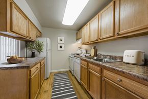 Woodbridge apartment for rent - a kitchen with wooden cabinets and a white refrigerator
