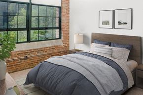 Ellicott City apartment for rent - a bedroom with a bed and a brick wall