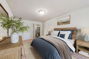 Oxon Hill apartment for rent - a bedroom with a bed with blue and white bedding and a wooden dresser