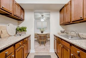 Oxon Hill apartment for rent - a kitchen with wooden cabinets and granite counter tops and a dining room with a table