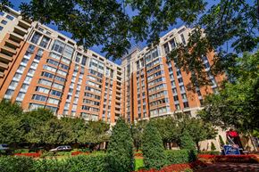 Bethesda apartment for rent - an exterior view of a large apartment building with trees and gardens