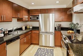 Towson apartment for rent - a large kitchen with stainless steel appliances and wood cabinets