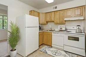 Baltimore apartment for rent - a kitchen with white appliances and wooden cabinets