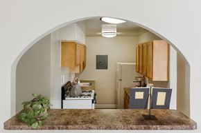 Capitol Heights apartment for rent - an arched doorway looking into a kitchen with a counter and a refrigerator