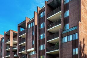 Pikesville apartment for rent - a tall brick building with balconies and a blue sky