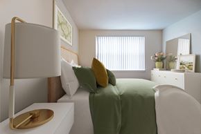 Baltimore apartment for rent - a bedroom with a green bed and a lamp