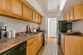 Capitol Heights apartment for rent - a kitchen with black appliances and wooden cabinets and counter tops
