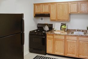 Laurel apartment for rent - a kitchen with black appliances and wooden cabinets