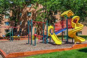 Laurel apartment for rent - a playground with yellow and red toys in front of a building