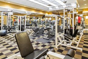 Baltimore apartment for rent - a gym with weights and cardio equipment on a checkered floor