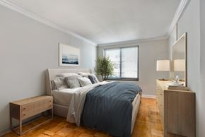 Bethesda apartment for rent - a bedroom with a bed and a dresser and a window