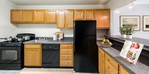 Bethesda apartment for rent - a kitchen with black appliances and wooden cabinets