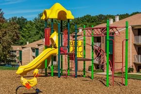 Vienna apartment for rent - a childrens playground with a yellow slide and other playground equipment in front of apartments