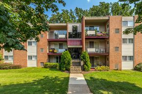Windsor Mill apartment for rent - exterior view of an apartment building with green grass and trees