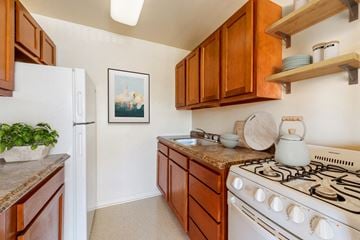 Adelphi apartment for rent - A kitchen with a white stove and wooden cabinets.