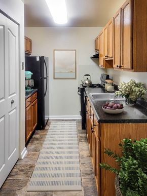 Owings Mills apartment for rent - a kitchen with black appliances and wooden cabinets