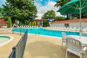 Owings Mills apartment for rent - our resort style swimming pool is filled with chairs and umbrellas