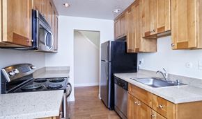 San Jose apartment for rent - an empty kitchen with wooden cabinets and stainless steel appliances
