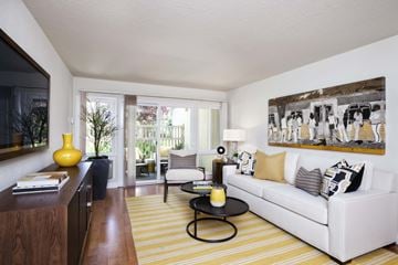 San Jose apartment for rent - a living room with a white couch and a yellow striped rug