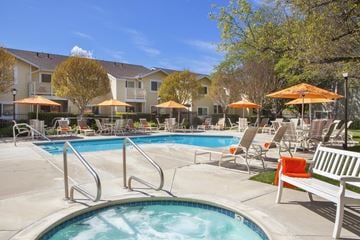 Gilroy apartment for rent - A pool with a hot tub and chairs around it.