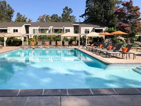 Cupertino apartment for rent - a swimming pool with chairs and umbrellas in front of a resort style pool