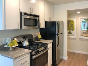 Mountain View apartment for rent - A black refrigerator sits next to a stove in a kitchen.