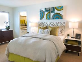 Mountain View apartment for rent - A bedroom with a large bed and a painting on the wall.