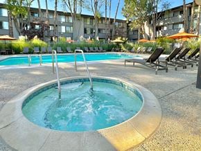 Mountain View apartment for rent - A round hot tub sits in the middle of a pool surrounded by chairs.