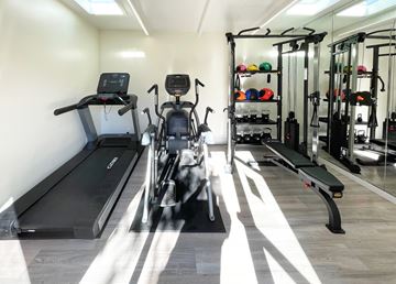 Sunnyvale apartment for rent - A gym with treadmills, exercise bikes, and weight racks.