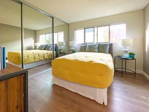 Santa Clara apartment for rent - A bedroom with a yellow bed and a mirror on the wall.