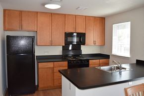 Wood-Ridge apartment for rent - a kitchen with black appliances and wooden cabinets
