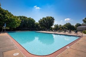 Reisterstown apartment for rent - a swimming pool with chairs and trees in the background