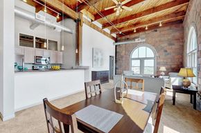 Omaha apartment for rent - a dining room with a table and a kitchen in a loft