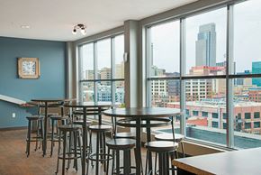 Omaha apartment for rent - a dining area with tables and chairs and a view of the city